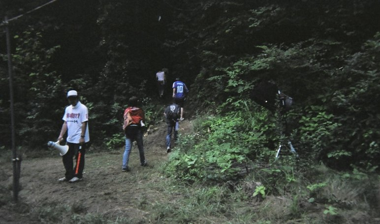 アバロン・フィールドのオーガニック・ビレッジの上に出られる抜け道。 03年はこういう標識もなにもなく、人が勝手に入っていく状態でした。04年はここにスタッフが常駐し、標識まで立っていました。しかも、途中にレジャーシートを敷いて休憩拠点にする人までいました。公式ガイドにもこのルートは載っていません。どうも、草木を刈り取って整備されたような跡があります。こうした「非公式ルート」はアバロン・フィールドのオーガニック・ビレッジとNGOビレッジの間にもあり、そこは前衛芸術家の作品発表の場にもなっています。