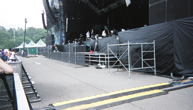 ステージと観客のエリアは10メートルくらいの緩衝帯があります。アーティストによってはこの緩衝帯を越え、観客エリア内に入る人も実際にいました。ホワイト・ステージではこの間隔はもっと狭くなります。公演中はここにセキュリティが観客の方を向いて立ち、カメラ撮影しようとする人を制止し、頭の上を転がっていく人を処理します