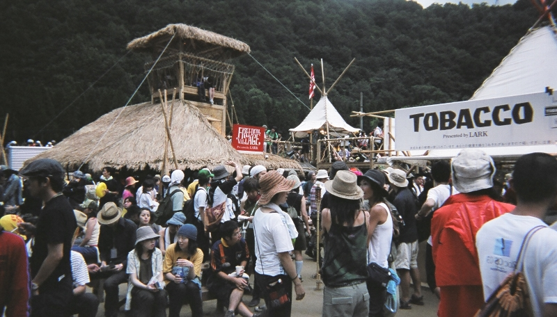 後方に建つ藁葺きのやぐらは食堂です。タイ・カレーに人気があります。そのとなりはタバコ屋です。この付近一帯が事実上喫煙所になっています。