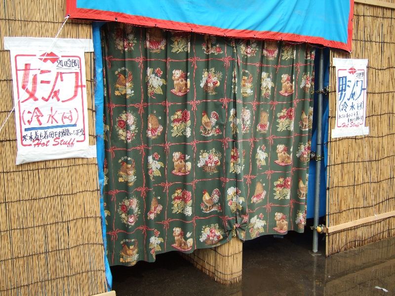 キャンプサイト利用者用シャワー。時間設定なしにいつでも利用することができますが、朝は3時間待ちということもあります。午前9時に並べば利用できるのは12時ごろです。毎年同じですが、水ではなく冷水が出ます。女性用の注意書きは「水着着用でお願いします」となっており、男性用は「あくまで基本は水着着用でお願いします」となっています。実際、男性で水着を着用している人はほとんどいません。男シャワーの場合、中に5基のシャワーがあります。