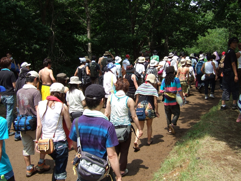 朝、グリーンステージからホワイト・ステージ方面へ向かう人の列。朝なので道はまだやわらかくありません。雨が降っていなくても、たくさんの人の足で踏まれて水分が地表に出てきます。したがって、夕方には泥道になります。