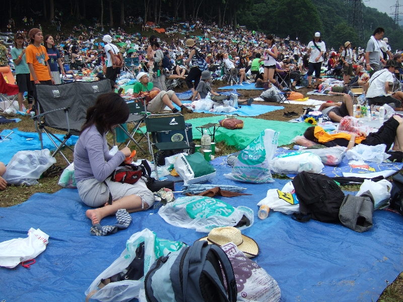 雨対策のため、多くの人が荷物をごみ袋の中に入れています。