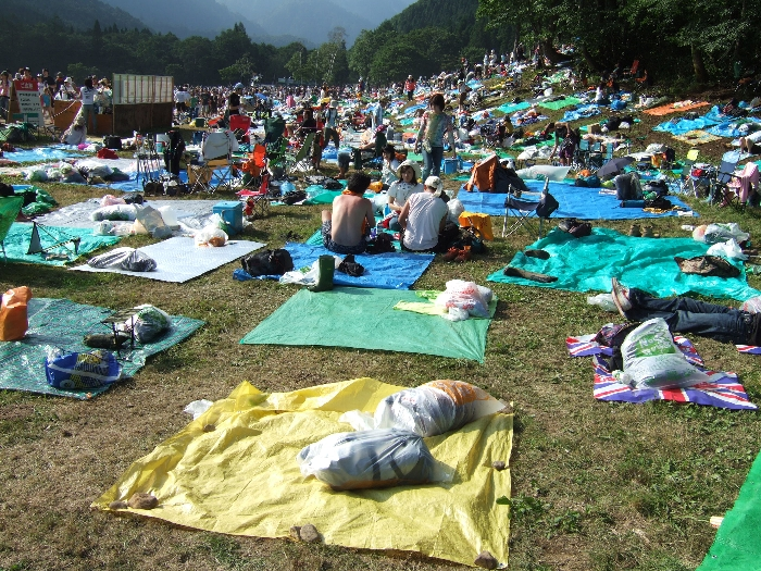 晴れていても荷物は袋に入れて雨対策をします。多くの人はグリーン・ステージ後方にレジャー・シートで拠点を作り、そこに荷物を置いて行動します。