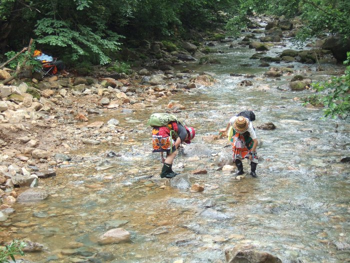 木の葉で舟を作り、川に流す女性2人。長靴で川に入っています。グリーン・ステージ側。 