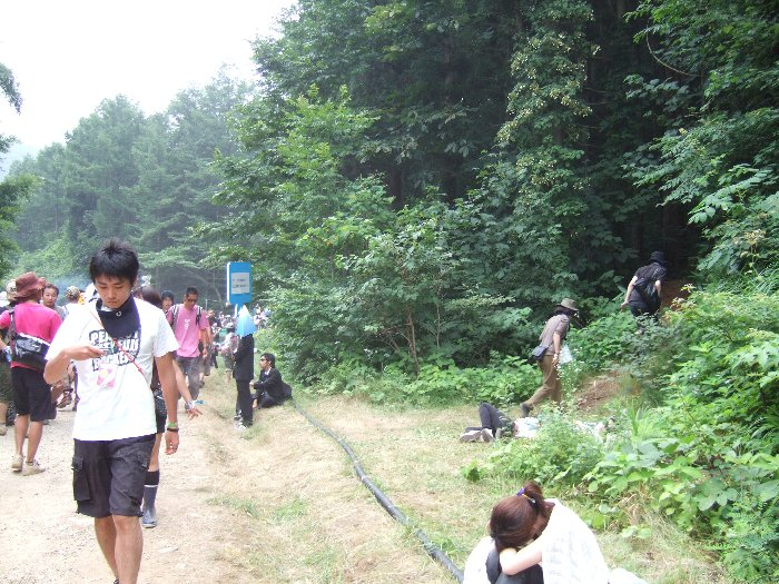 フィールド・オブ・ヘブンからアバロン・フィールドのオーガニック・ビレッジへ行く抜け道がありますが、正規の通路ではありません。かつてはフィールド・オブ・ヘブン側の入り口にアルバイトのスタッフが立っていたこともありましたが、今回は（見た限りでは）誰もいませんでした。左側が正規の通路で、奥に仮設トイレがあります。右は抜け道を入っていく人。 