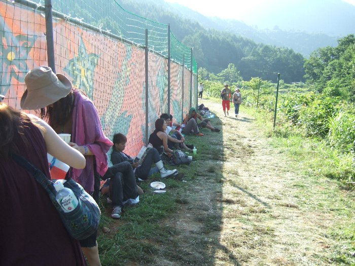 ステージに近い部分になるとフェンスで覆われます。チケット、リストバンドを持たない人が国道17号から山と川を越えて侵入してくるのを防ぐためか。 