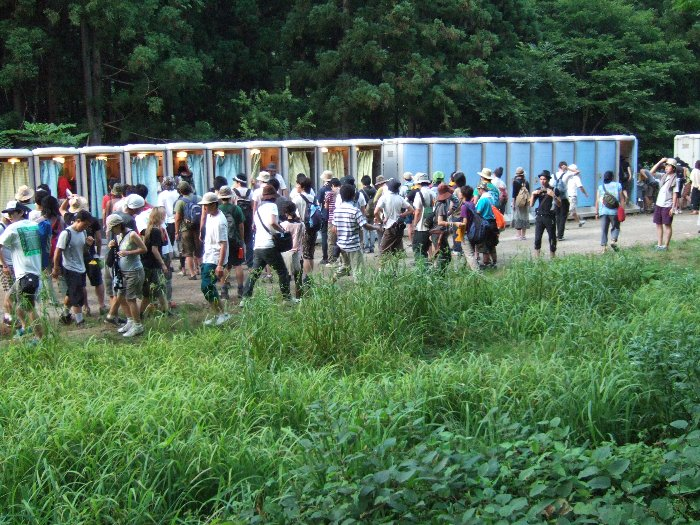 会場内での一般的なトイレ風景。右側は扉が完全に閉まるトイレ、左はカーテンで閉じるトイレ。カーテンのトイレは男性の小便用。トイレの機能としては右側と同じで、大便をしても問題はありませんが、実際にする人はまずいません。女性もまったく利用しません。 