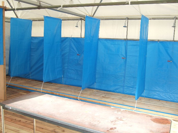 冷水シャワーの内部。手前の机に衣服や所持品を置きます。管理、紛失、盗難は自己責任です。利用開始前に内部が見える状態だったところを撮影。実際の利用時は白いビニールで覆われており、内部は当然見えません。 