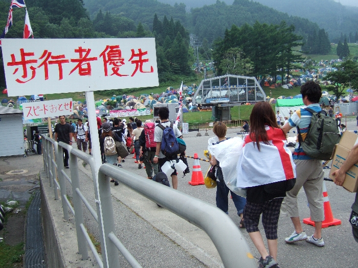 注意書きの横を通る人たち。 