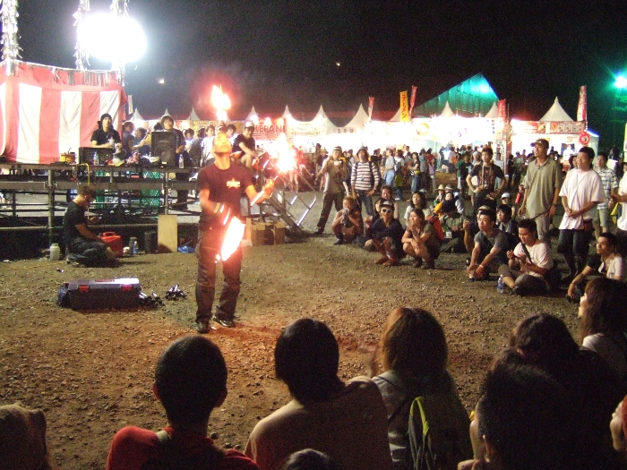 オアシスエリアで火をジャグリングする人。 