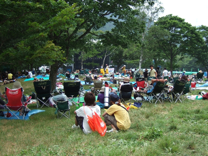 いすと木々のすき間からステージを眺めます。 