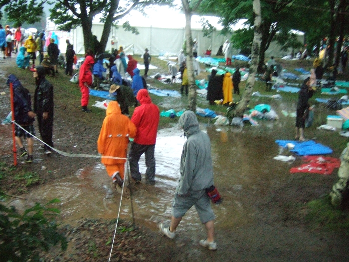 水たまりに突っ込んでいく人。長靴着用。 