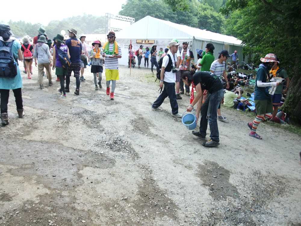 ポカリスエットの店の前で水まきする人。
