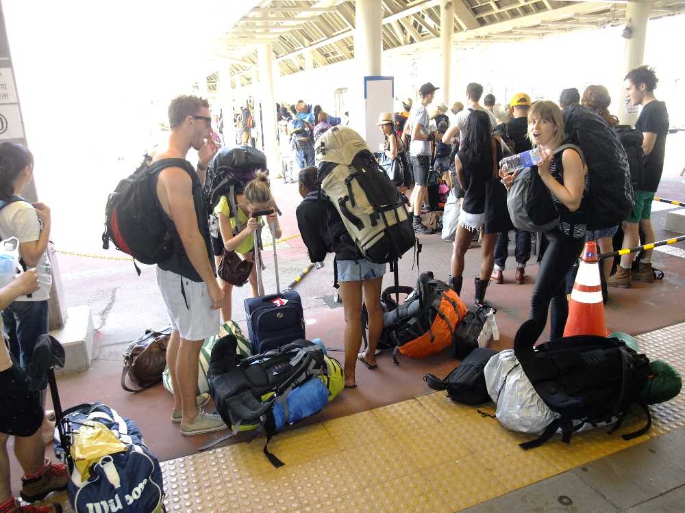 シャトルバスの行列。宅配便が使いにくい外国人は荷物が大きい。