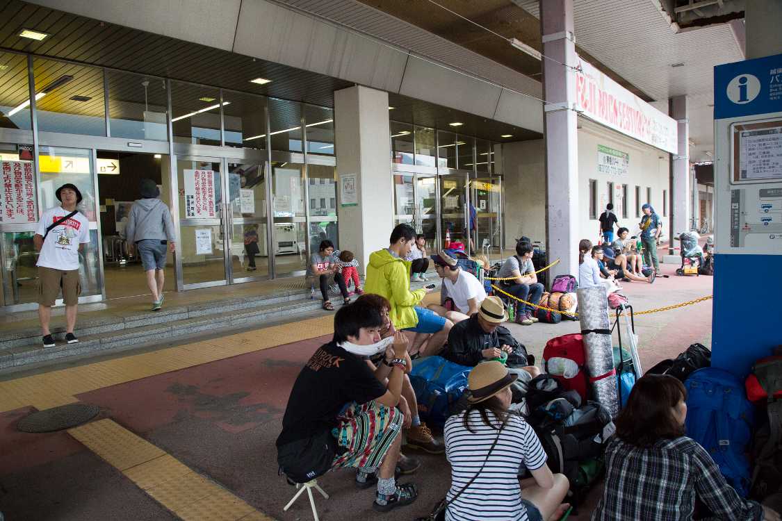 シャトルバスの行列はいったん折れて駅内に行列が続く。