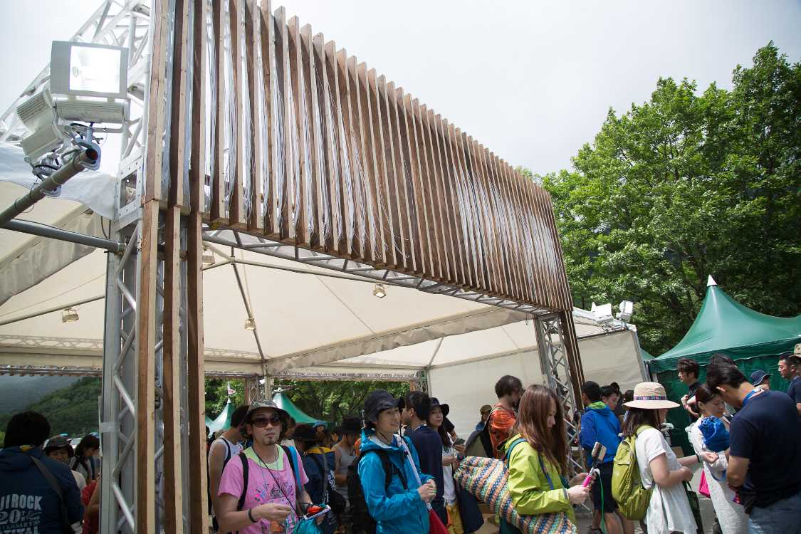 入場ゲートの会場側は、風が吹くと縦格子の間から繊維の束が見えるようになっています。