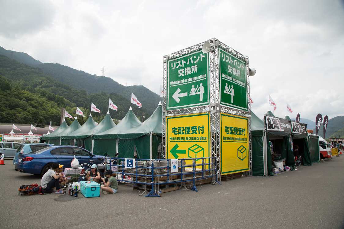 駐車場、場外導線から見えるリストバンド交換所の大きな看板。