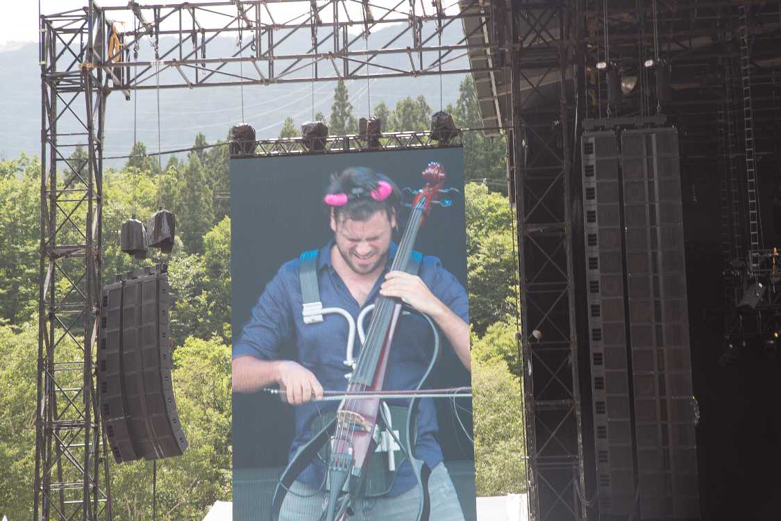 AC/DCのライブで使われる赤い角を頭につけています。AC/DCは「サンダーストラック」「狂った夜」「ハイウェイ・トゥ・ヘル」「バック・イン・ブラック」の4曲も演奏しました。アンガス・ヤングがギターを弾きながら前屈みで歩く定番のパフォーマンスを、チェロで再現していました。