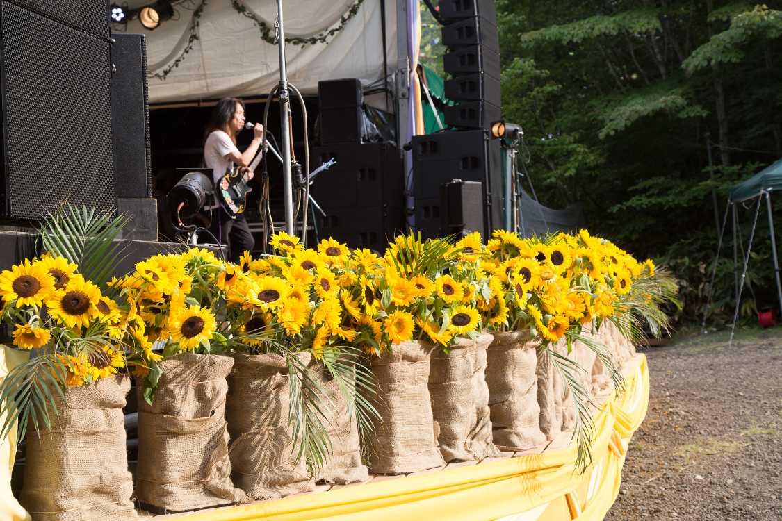 ステージの前にひまわりがあるのは例年変わりませんが、ひまわりの下の装飾は変わります。今年はとても質素です。