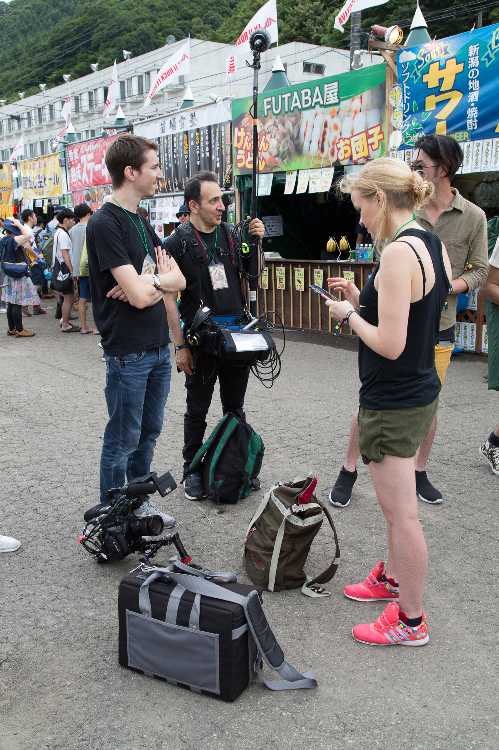 場外で取材する外国人。