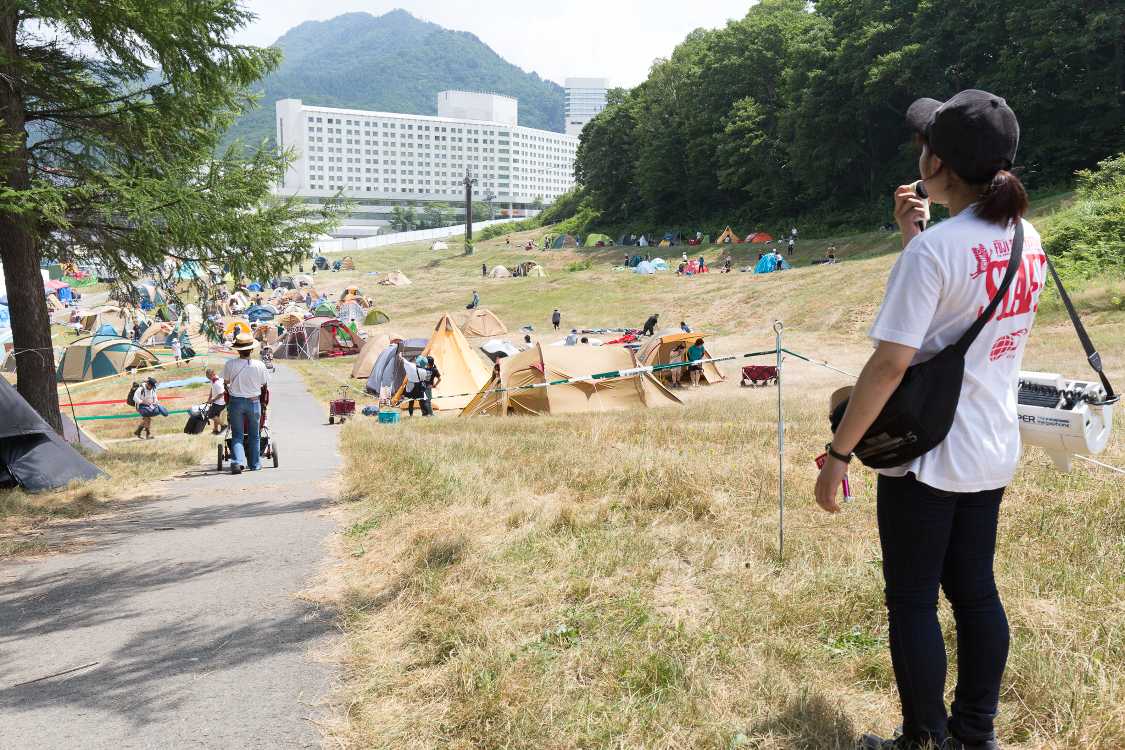 登ってくるキャンプサイト利用者を案内するスタッフ。