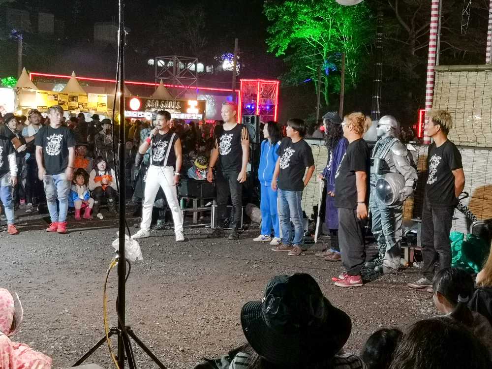 日曜日の深夜、大道芸人がオアシスエリア集結。あいさつするフレディー・マーキュリーのものまね芸人。