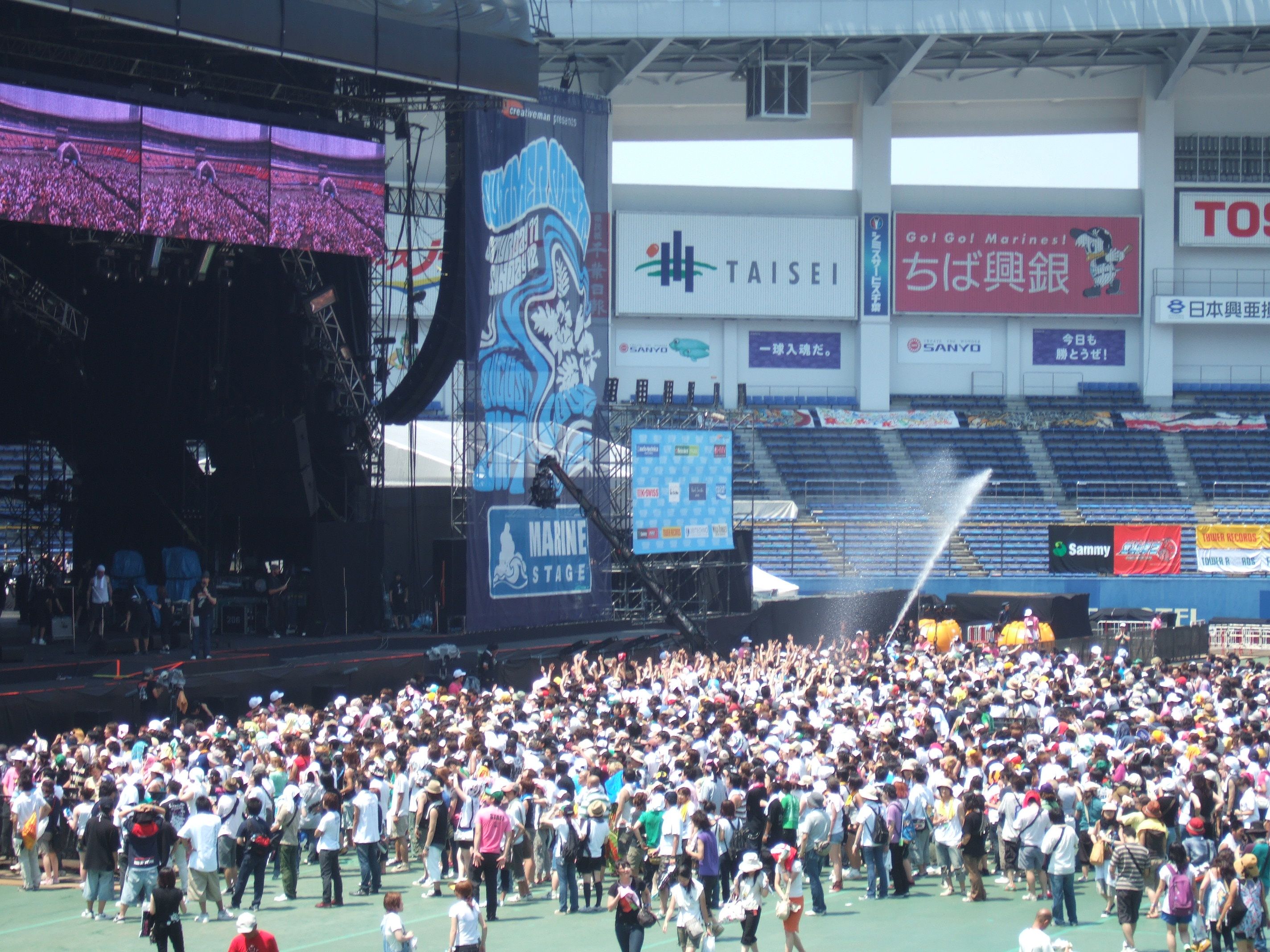 熱中症対策の水まき。グラウンドにシートを敷いているので土ぼこり対策ではありません。