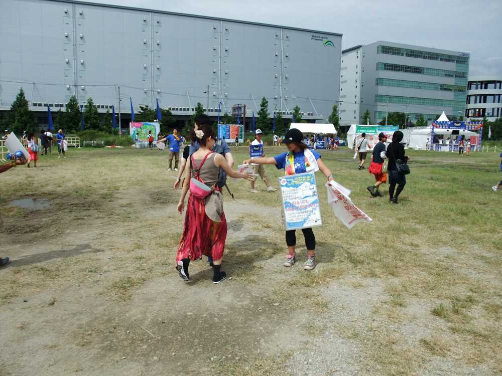 シャトルバス降り場の広い空き地。ごみ袋を配っています。
