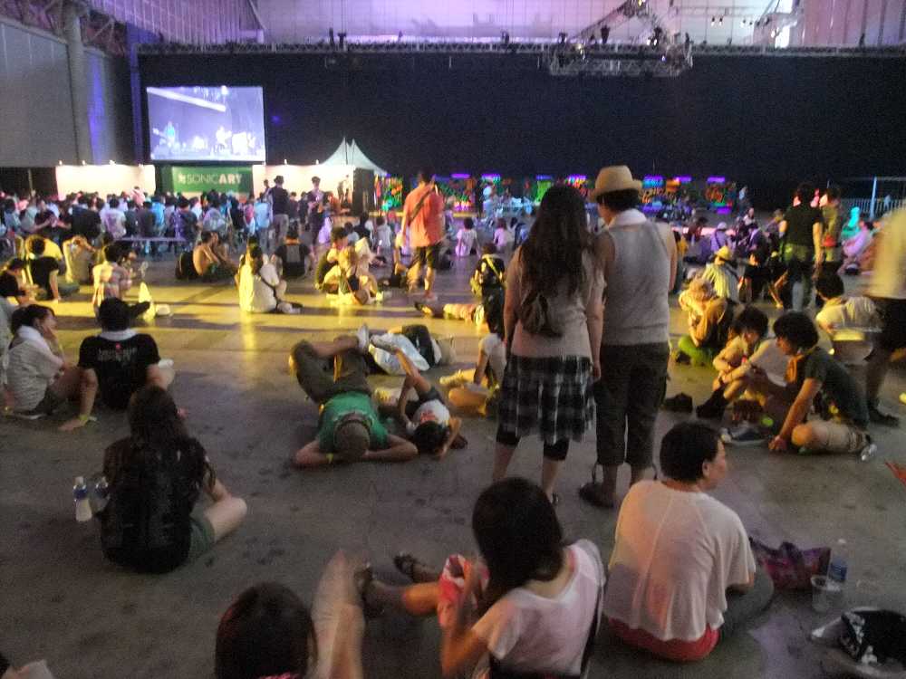 後方では座ったり寝たりしている人が多い。