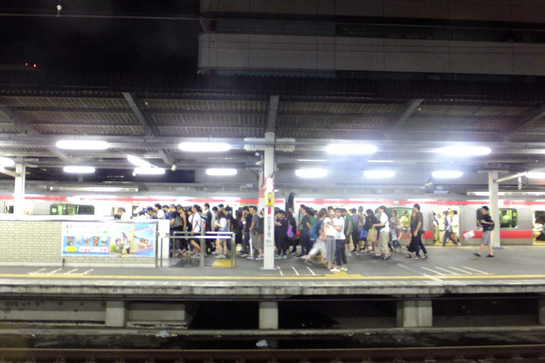 海浜幕張駅ホーム。東京方面から来た電車と多数の客。