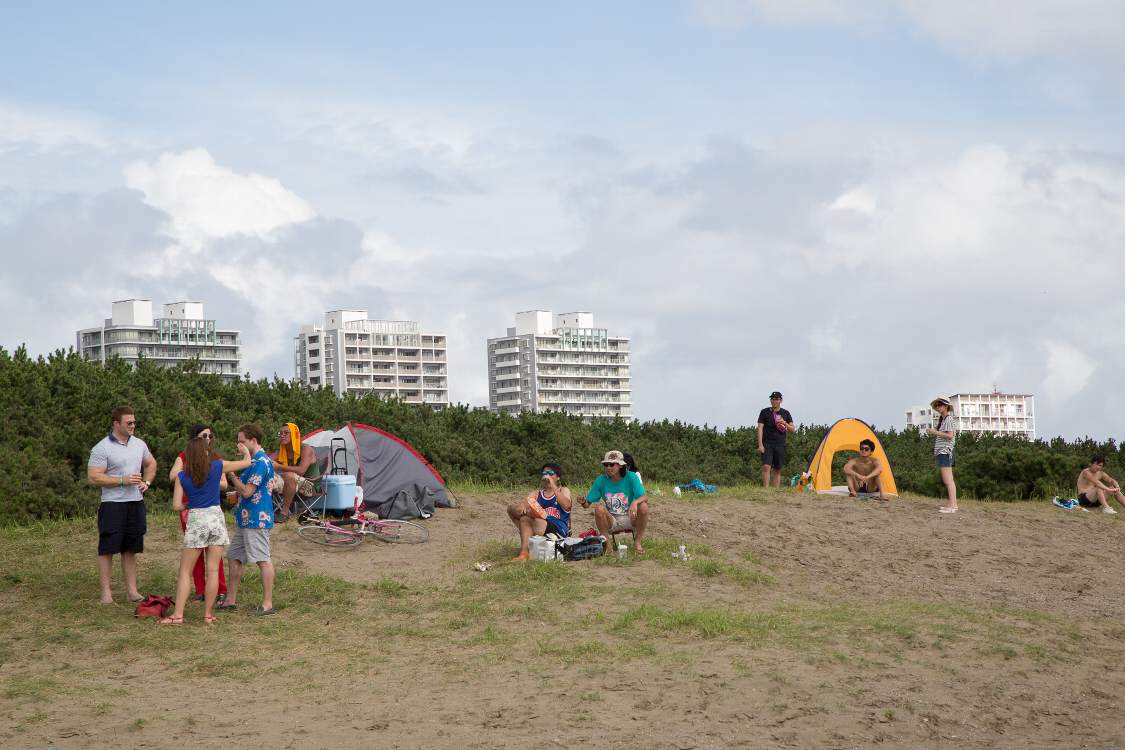 遠くからビーチステージを眺める人。ステージ自体は見えません。
