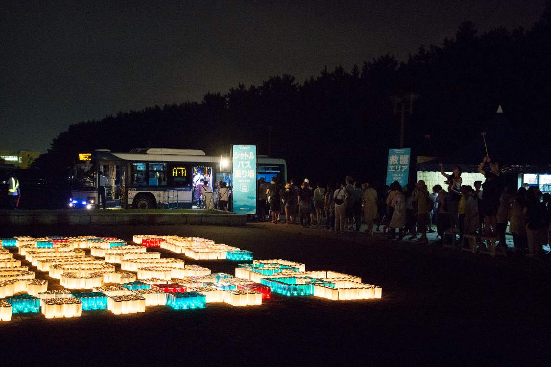 シャトルバス乗り場。右側にロウソクの写真を撮る人がいます。