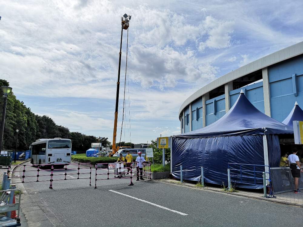 入場ゲートの反対側。臨時の携帯電話用アンテナがあります。バスは関係者用シャトルバス。