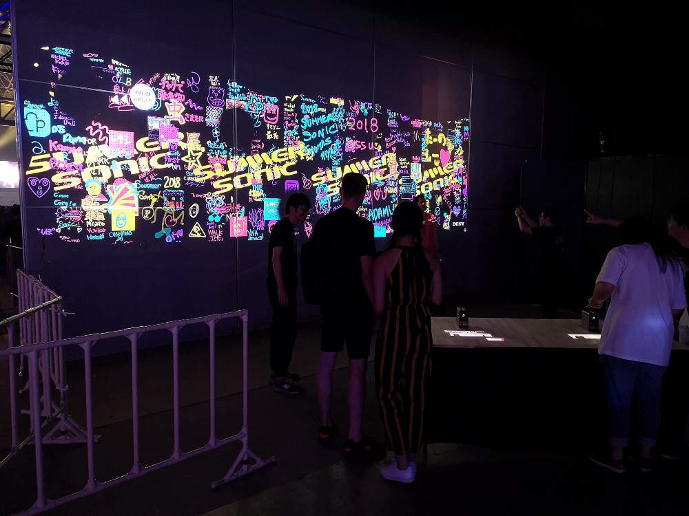 指で書いた字やイラストが壁に映し出されるアート。